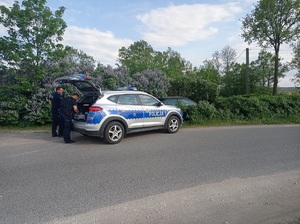 policjanci stoją przy radiowozie
